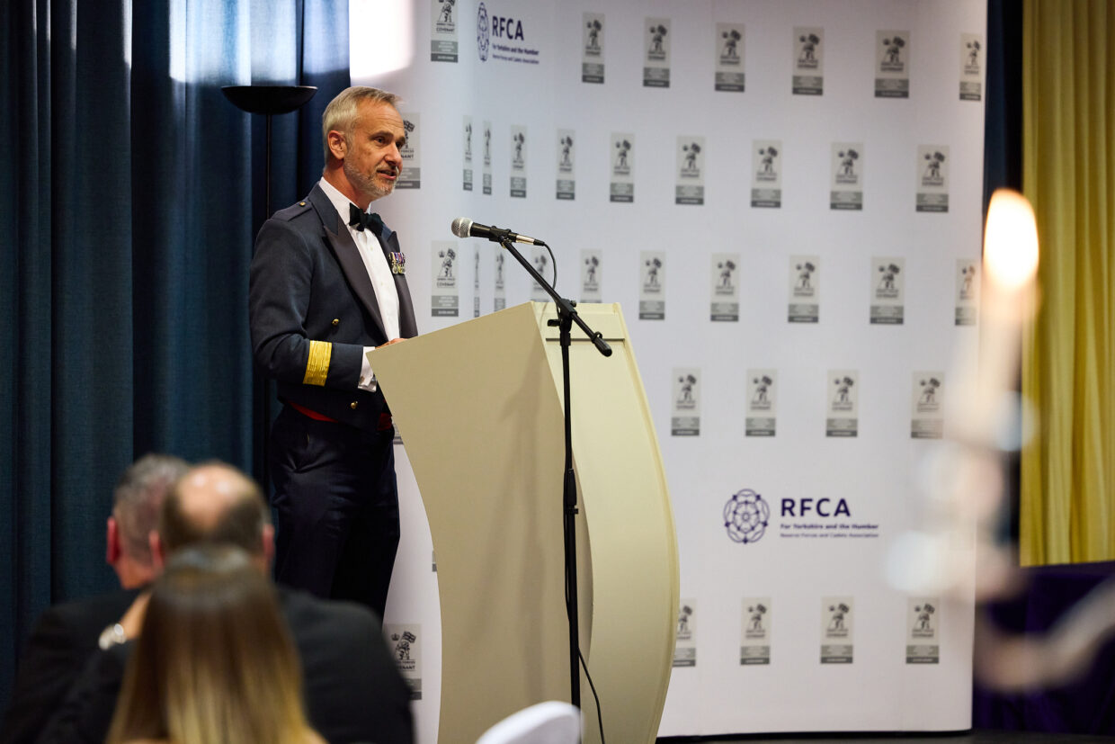 A man in uniform standing behind a lectern