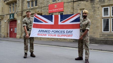 Two reserves from 4YORKS carry the Armed Forces Week flag